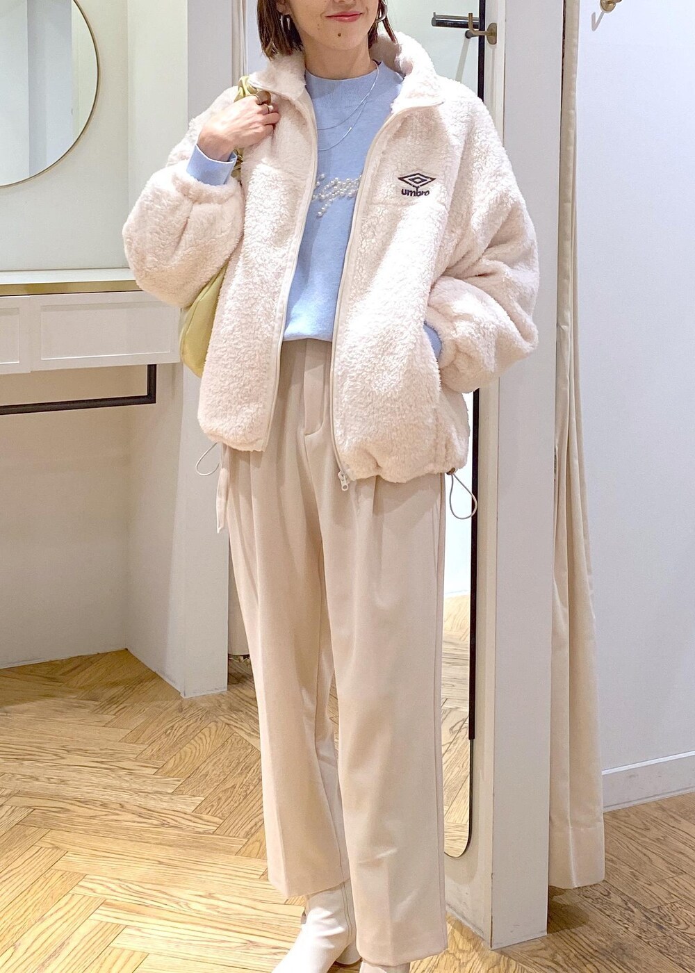 ホワイト系のブーツ、ホワイト系のブルゾン、ブルー系のニット/セーターを着用したレディースの冬コーディネートの6枚目の写真