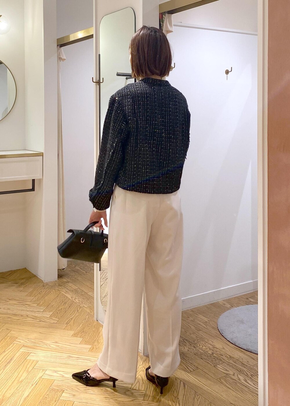 ブラック系のパンプス、ベージュ系のシャツ/ブラウス、ホワイト系のスラックスを着用したレディースの冬コーディネートの3枚目の写真