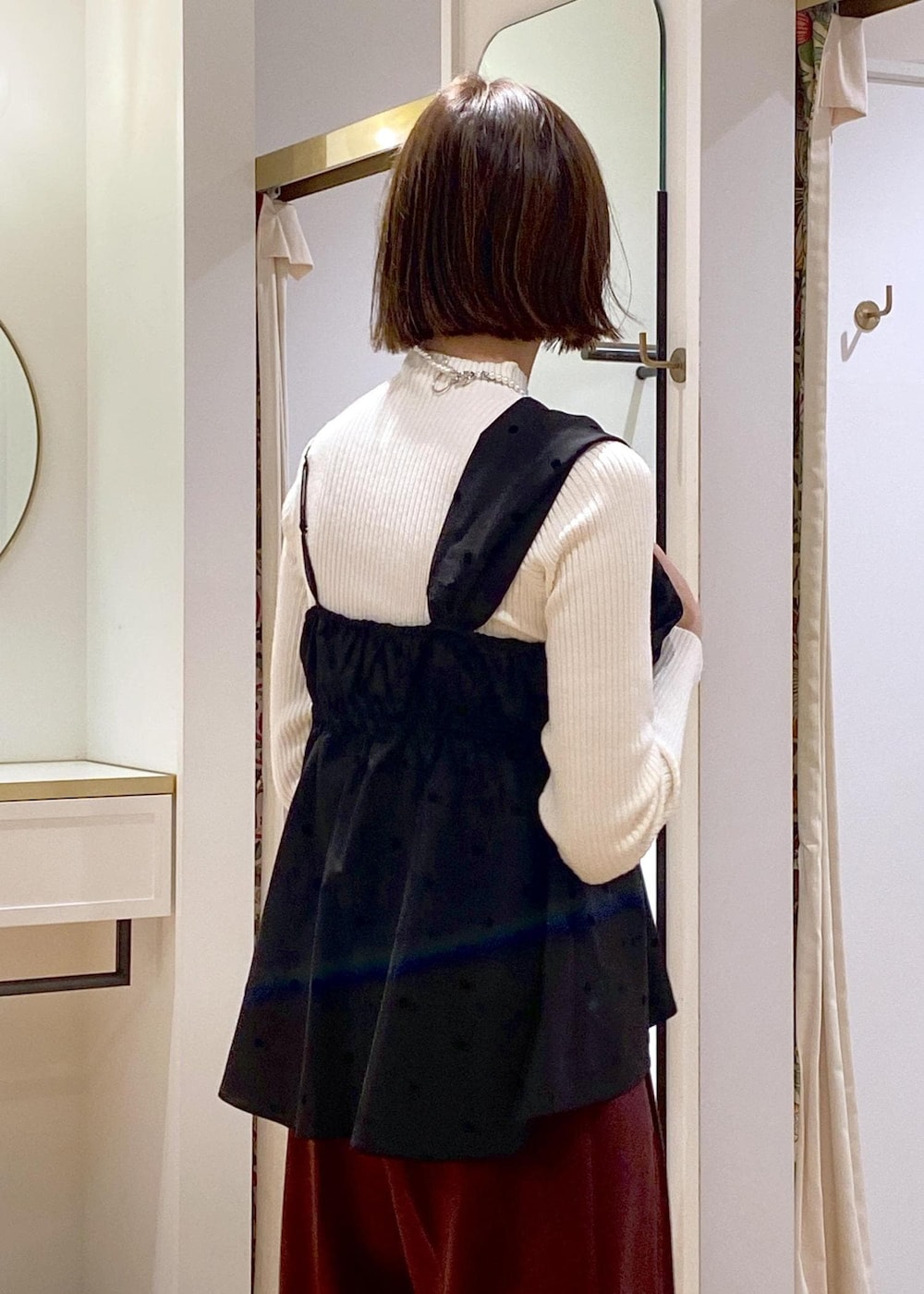 ブラック系のパンプス、ブラック系のキャミソール、ホワイト系のニット/セーターを着用したレディースの冬コーディネートの8枚目の写真