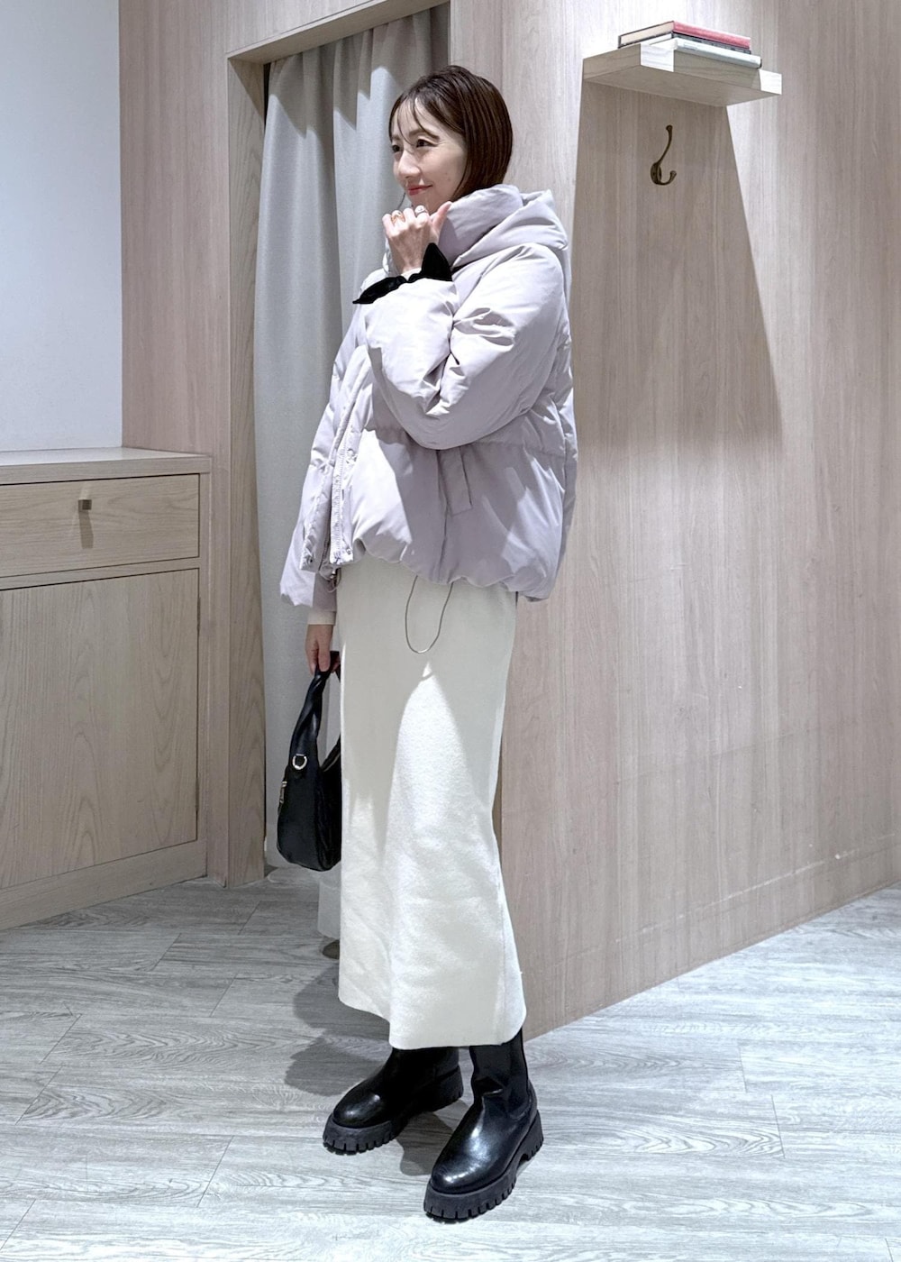 ブラック系のハンドバッグ、ピンク系のダウンジャケット/コート、ホワイト系のワンピースを着用したレディースの冬コーディネートの4枚目の写真