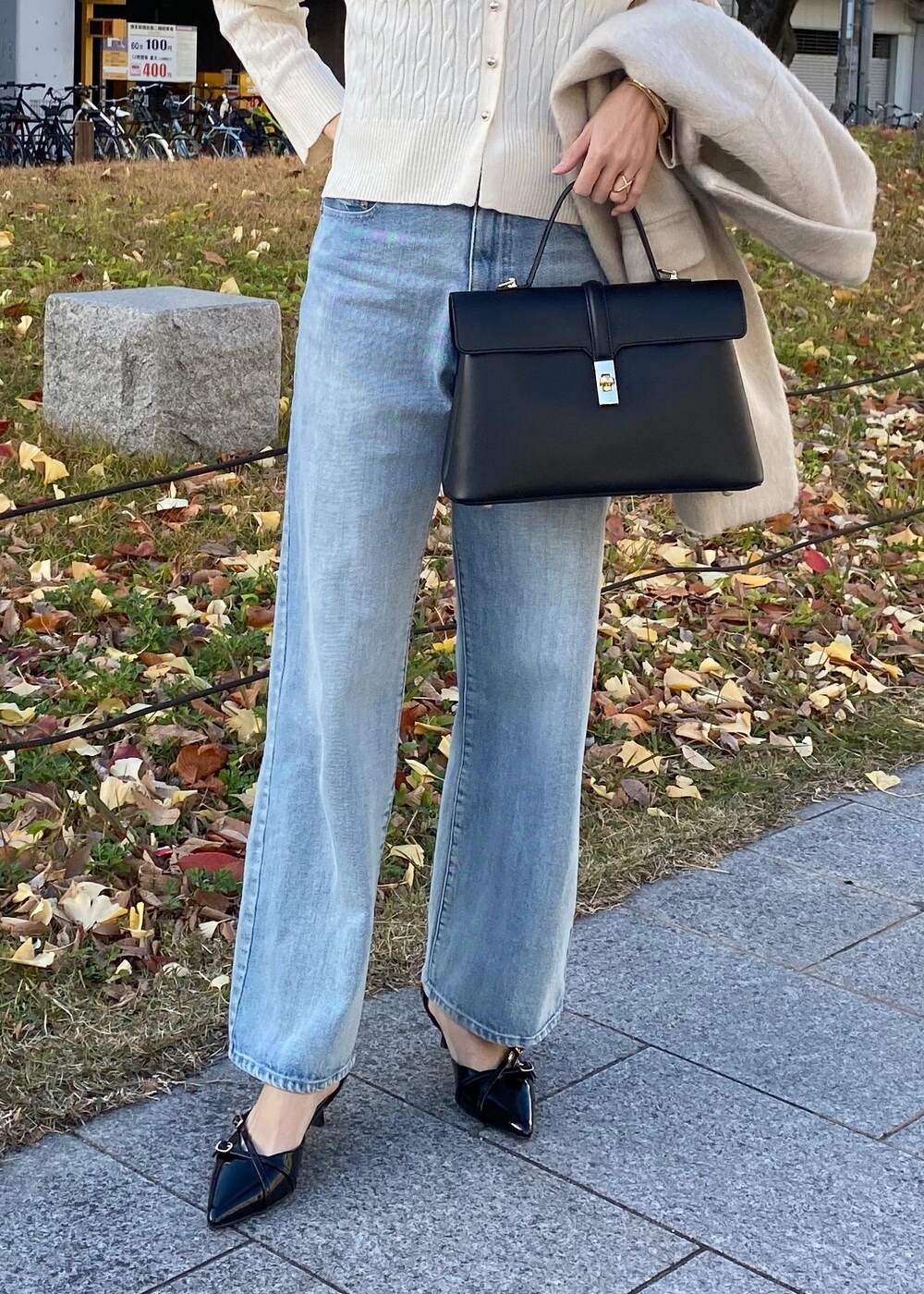 ブラック系のパンプス、ホワイト系のカーディガン/ボレロ、ベージュ系のその他アウターを着用したレディースの冬コーディネートの4枚目の写真