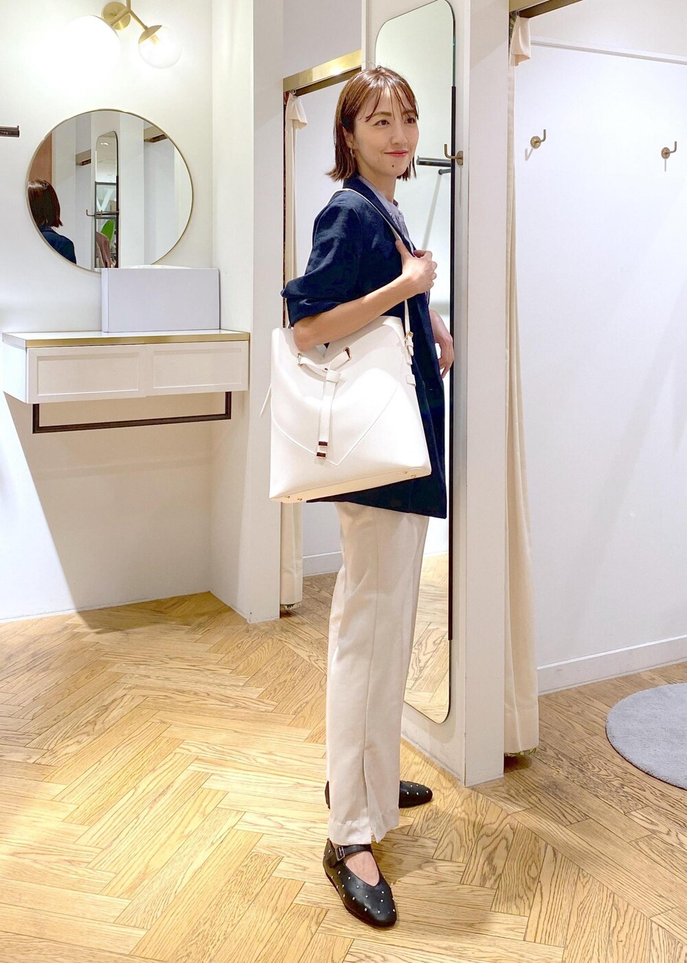 ブルー系のテーラードジャケット、ブルー系のシャツ/ブラウス、ホワイト系のスラックスを着用したレディースの夏コーディネートの2枚目の写真