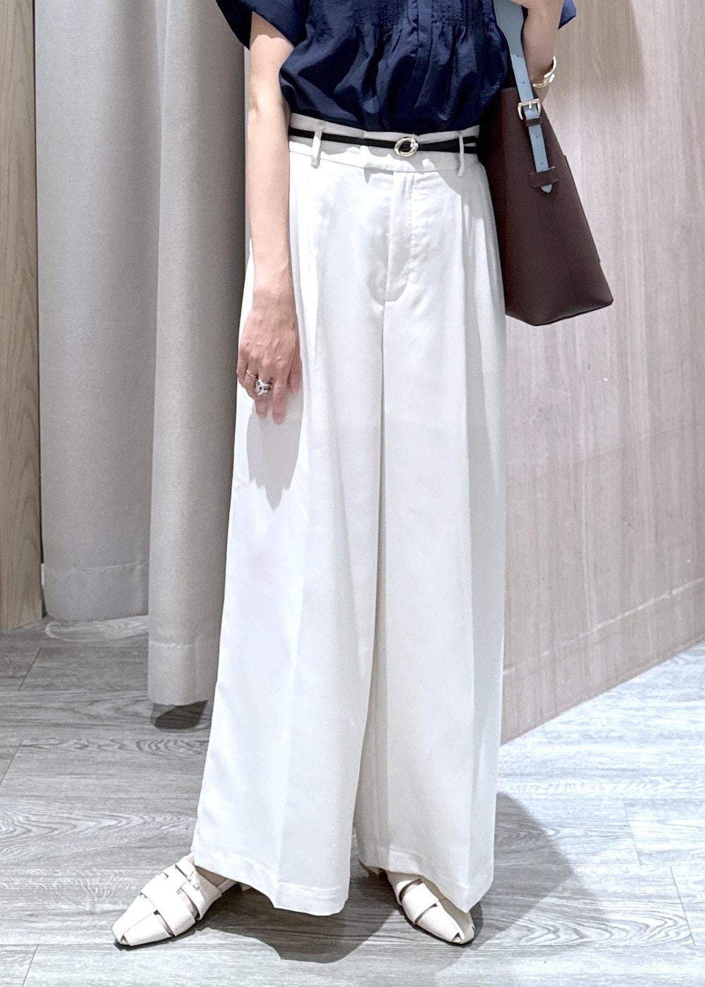 ブラウン系のトートバッグ、ホワイト系のパンプス、ブルー系のシャツ/ブラウスを着用したレディースの夏コーディネートの5枚目の写真