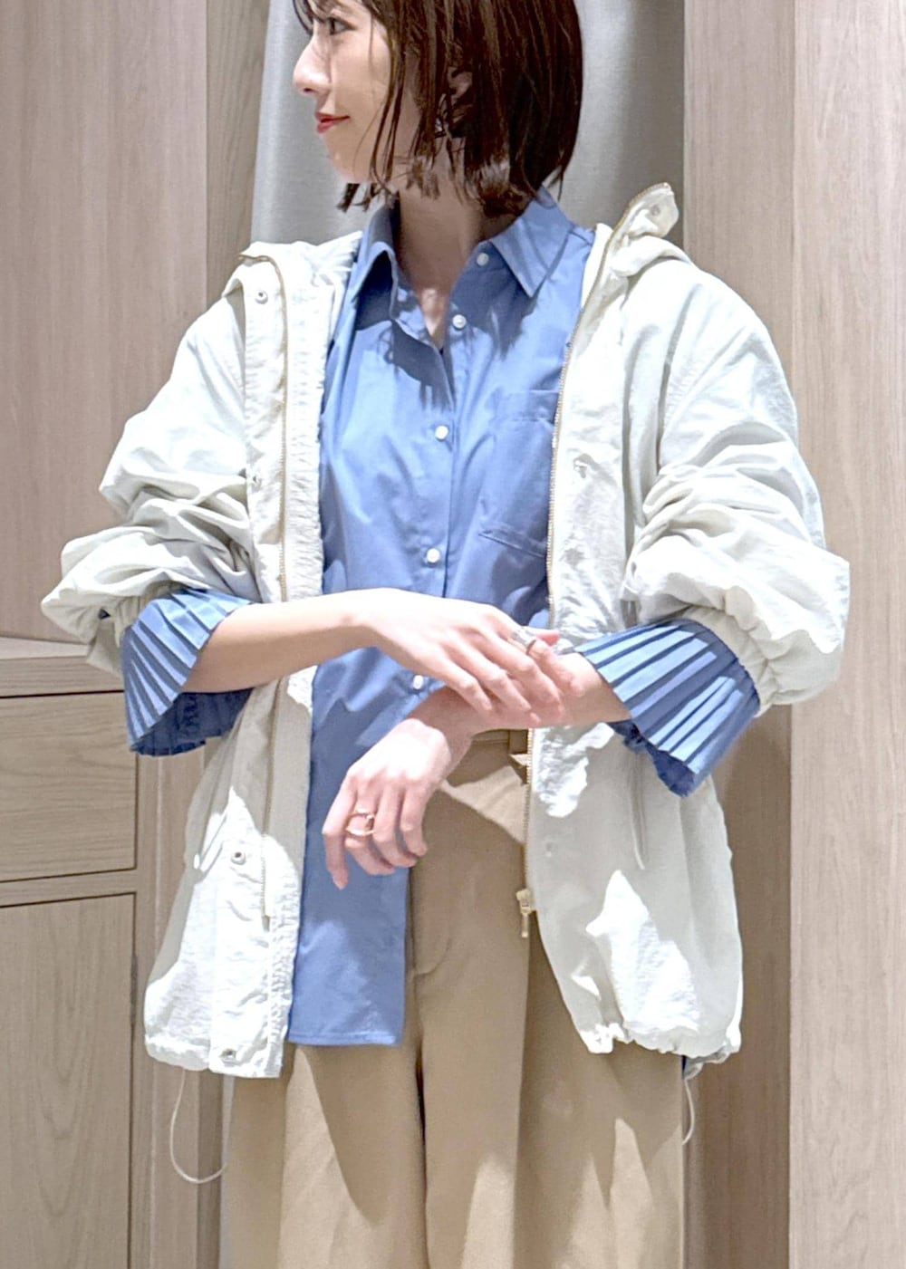 ブラック系のショルダーバッグ、ホワイト系のマウンテンパーカー、ブルー系のシャツ/ブラウスを着用したレディースの春コーディネートの8枚目の写真