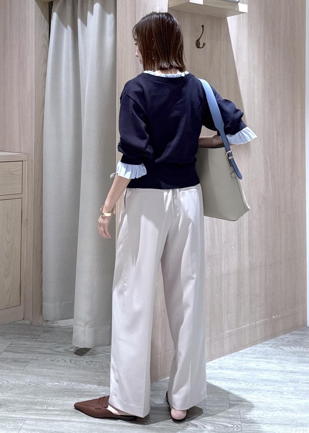 ベージュ系のトートバッグ、ベージュ系のその他パンツ、ブルー系のニット/セーターを着用したレディースの冬コーディネートの3枚目の写真