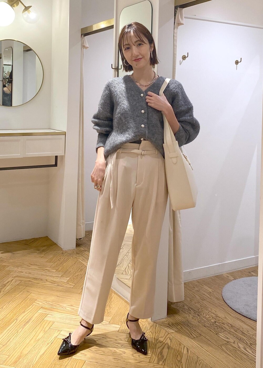 ホワイト系のトートバッグ、ブラック系のパンプス、ベージュ系のその他パンツを着用したレディースの冬コーディネートの2枚目の写真