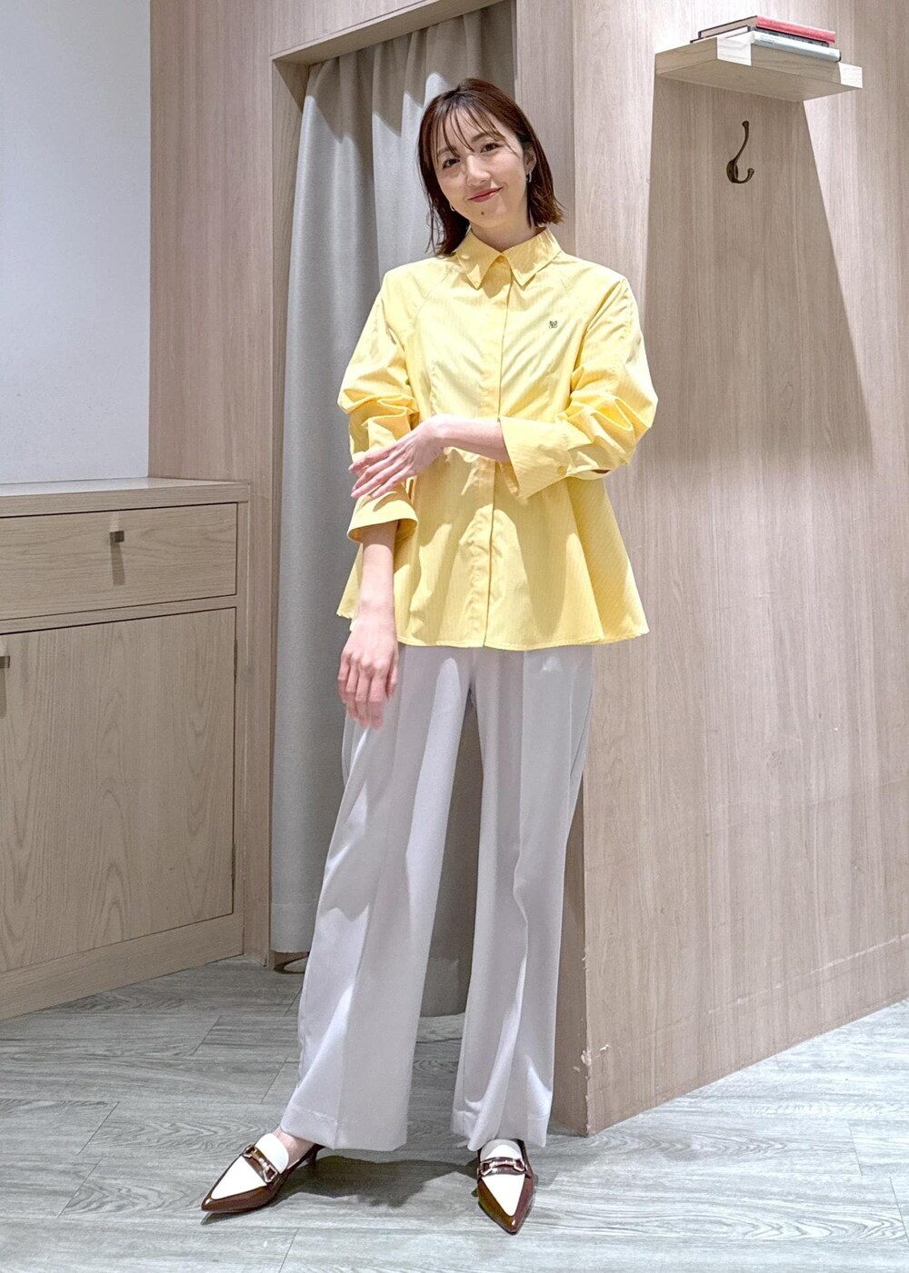 ブラウン系のパンプス、イエロー系のシャツ/ブラウス、ベージュ系のスラックスを着用したレディースの春コーディネートの9枚目の写真