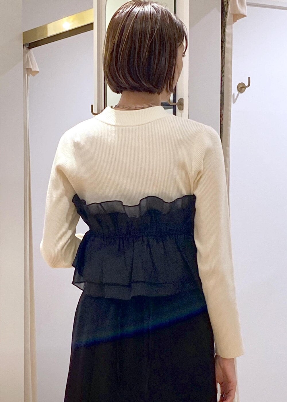 シルバー系のブーツ、ブラック系のスカート、ホワイト系のニット/セーターを着用したレディースの冬コーディネートの8枚目の写真