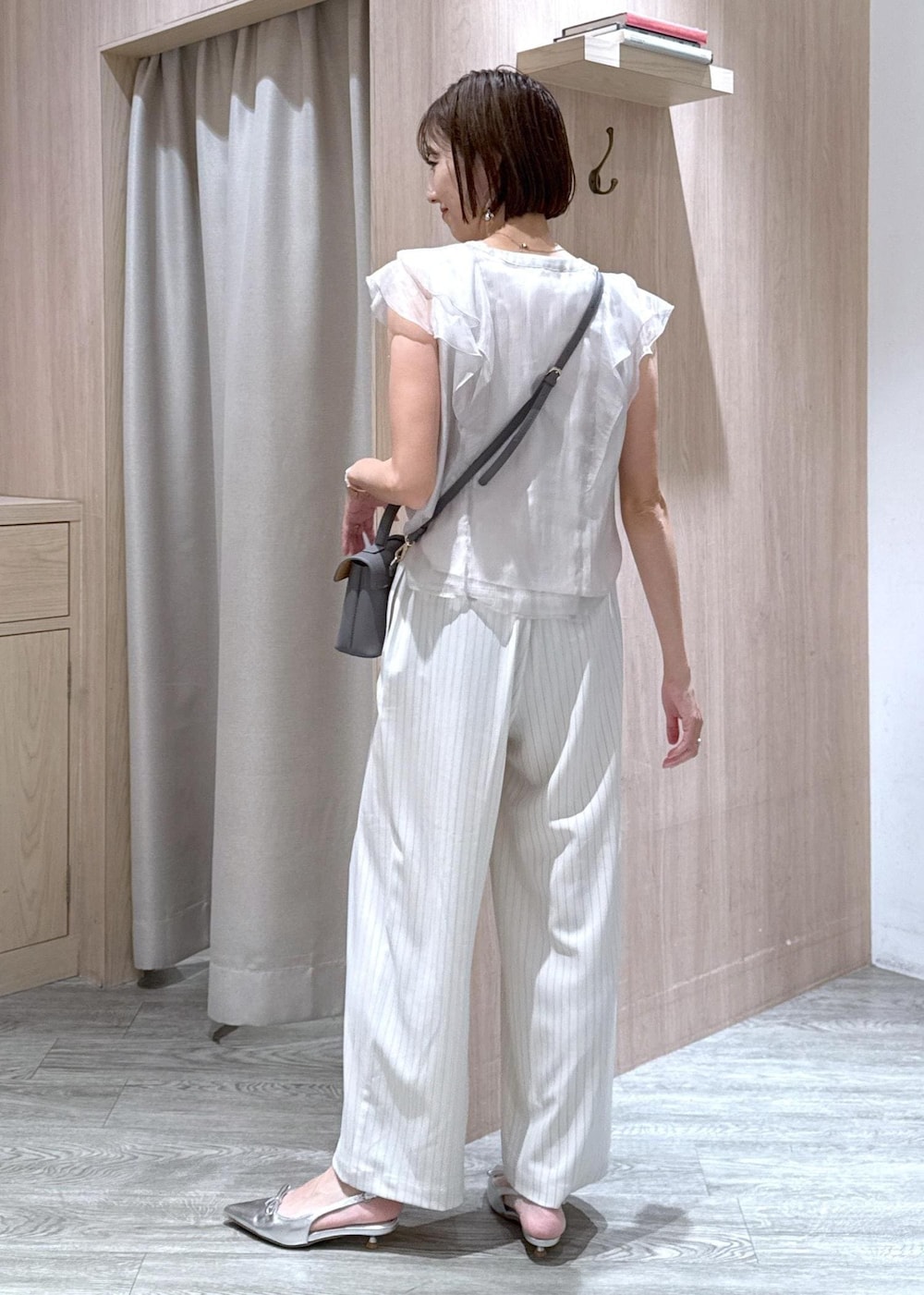 グレー系のショルダーバッグ、シルバー系のパンプス、ベージュ系のシャツ/ブラウスを着用したレディースの夏コーディネートの3枚目の写真