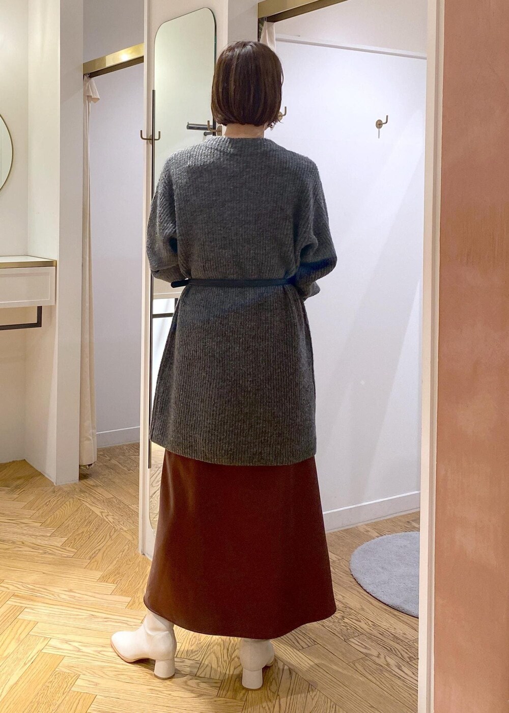 ホワイト系のブーツ、ブラウン系のスカート、グレー系のワンピースを着用したレディースの冬コーディネートの3枚目の写真