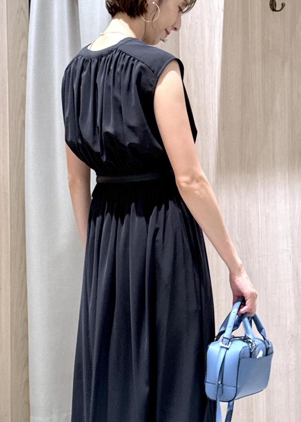 ブラック系のサンダル、ホワイト系のスラックス、ブラック系のワンピースを着用したレディースの夏コーディネートの10枚目の写真