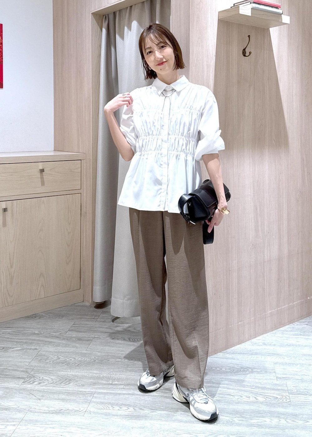 ホワイト系のシャツ/ブラウス、ブラック系のショルダーバッグ、グリーン系のスラックスを着用したレディースの春コーディネートの2枚目の写真