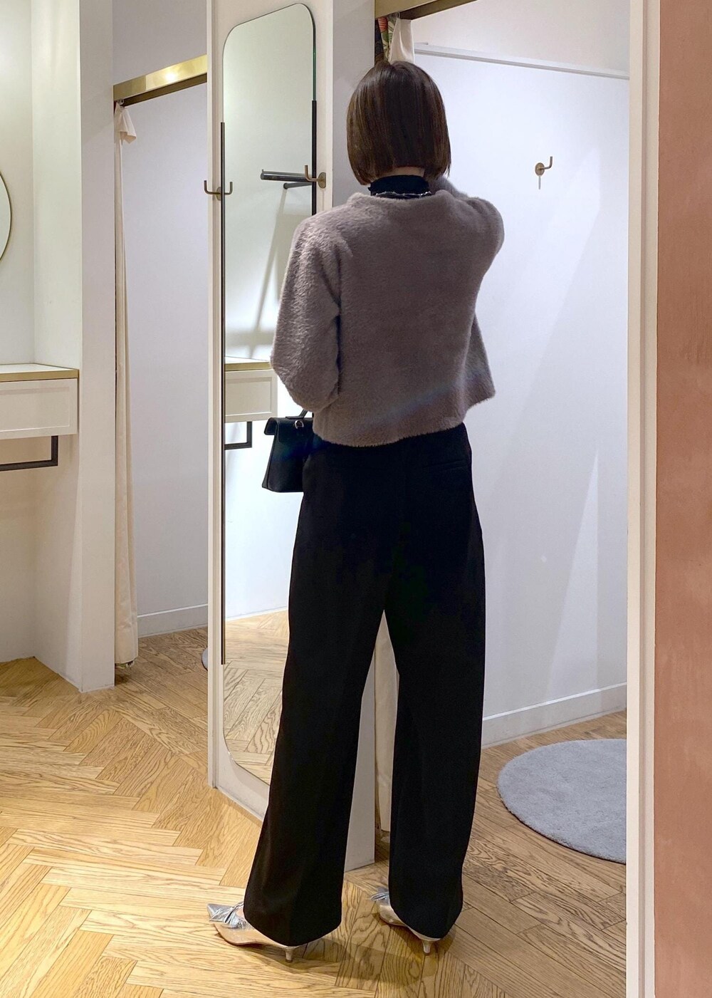 シルバー系のパンプス、ブラウン系のカーディガン/ボレロ、ブラック系のTシャツ/カットソーを着用したレディースの冬コーディネートの3枚目の写真