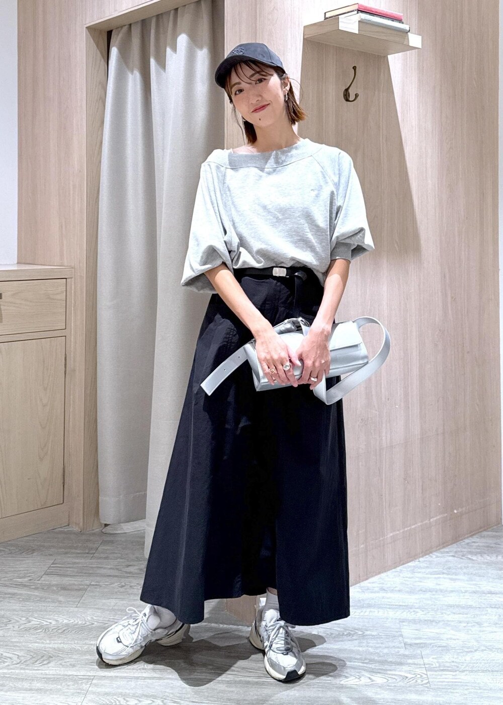 シルバー系のショルダーバッグ、ブラック系のスカート、ホワイト系のキャミソールを着用したレディースの秋コーディネートの2枚目の写真