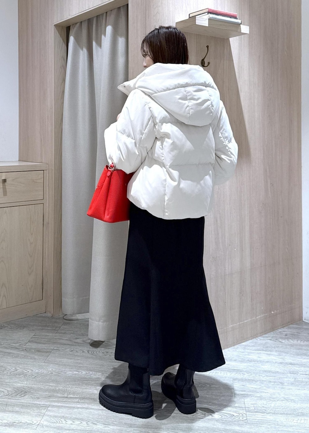 ブラック系のスカート、ブラック系のブーツ、グレー系のニット/セーターを着用したレディースの冬コーディネートの3枚目の写真