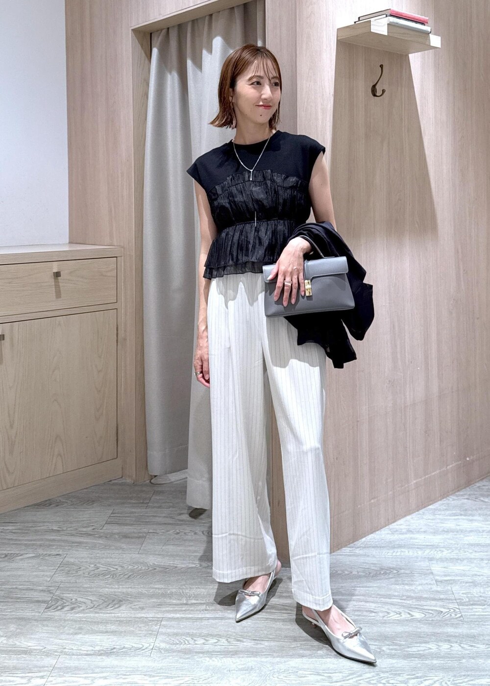 グレー系のショルダーバッグ、シルバー系のパンプス、ブラック系のTシャツ/カットソーを着用したレディースの夏コーディネートの8枚目の写真