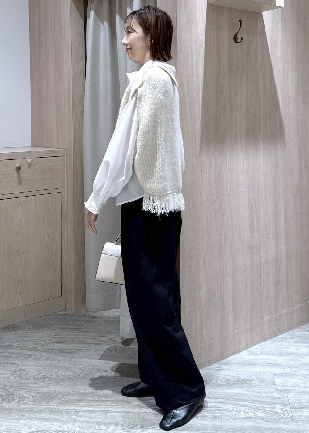 ブラック系のスラックス、ホワイト系のベスト、ホワイト系のシャツ/ブラウスを着用したレディースの秋コーディネートの10枚目の写真