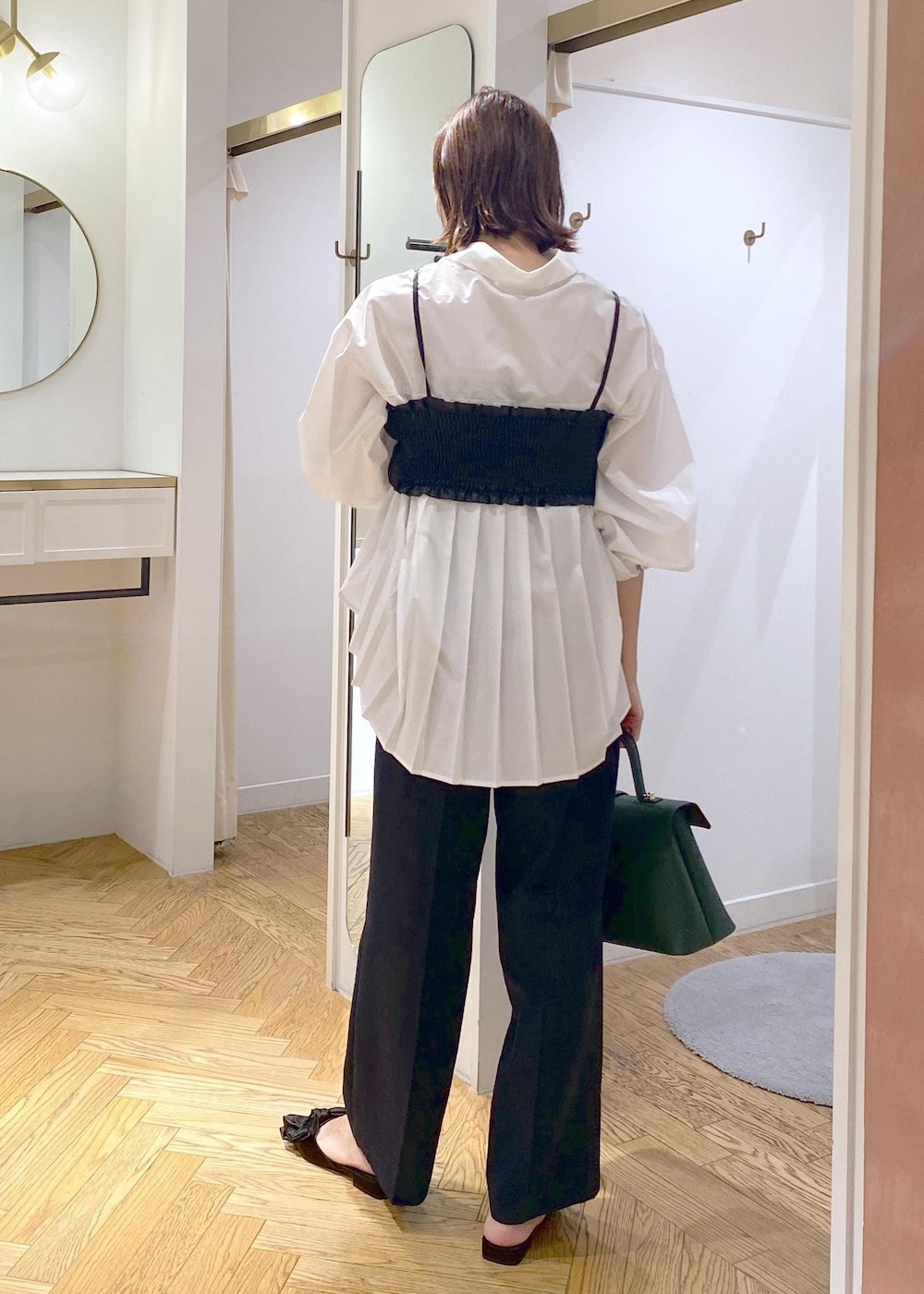 ブルー系のスラックス、ホワイト系のシャツ/ブラウス、グリーン系のハンドバッグを着用したレディースの秋コーディネートの3枚目の写真