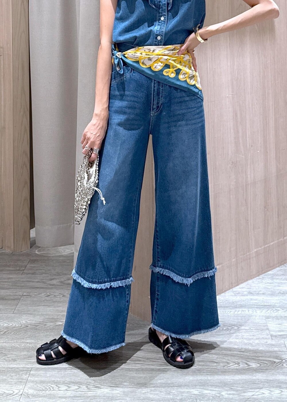 シルバー系のハンドバッグ、ブルー系のシャツ/ブラウス、ブルー系のデニムパンツを着用したレディースの夏コーディネートの5枚目の写真