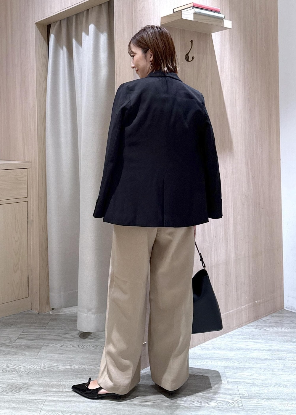 ブラック系のパンプス、ブラック系のトートバッグ、ブルー系のシャツ/ブラウスを着用したレディースの秋コーディネートの3枚目の写真