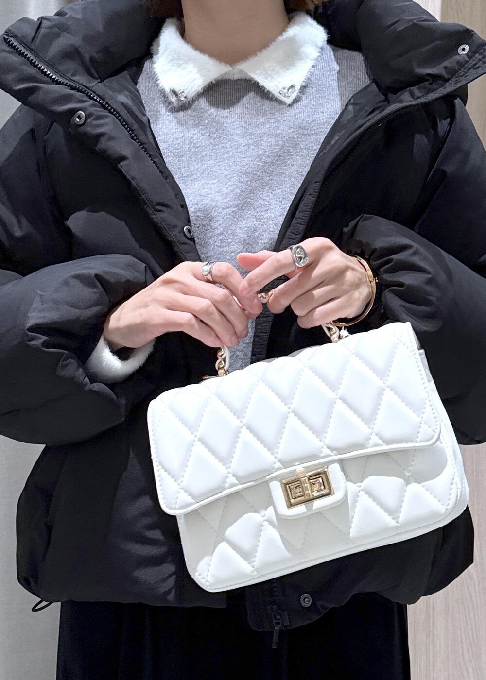 ブラック系のブーツ、ブラック系のスカート、ブラック系のダウンジャケット/コートを着用したレディースの冬コーディネートの9枚目の写真