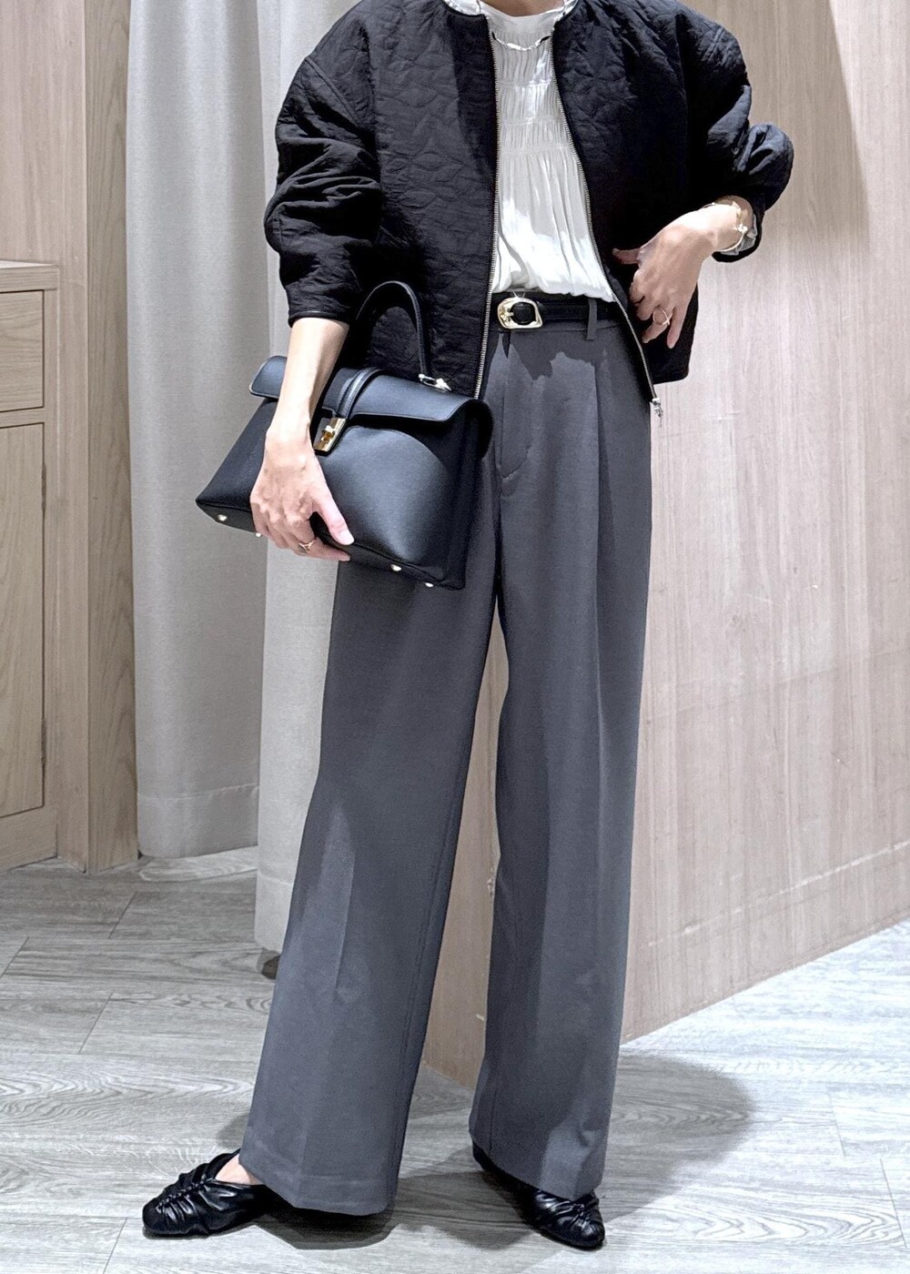 ブラック系のハンドバッグ、グレー系のスラックス、ホワイト系のシャツ/ブラウスを着用したレディースの秋コーディネートの7枚目の写真