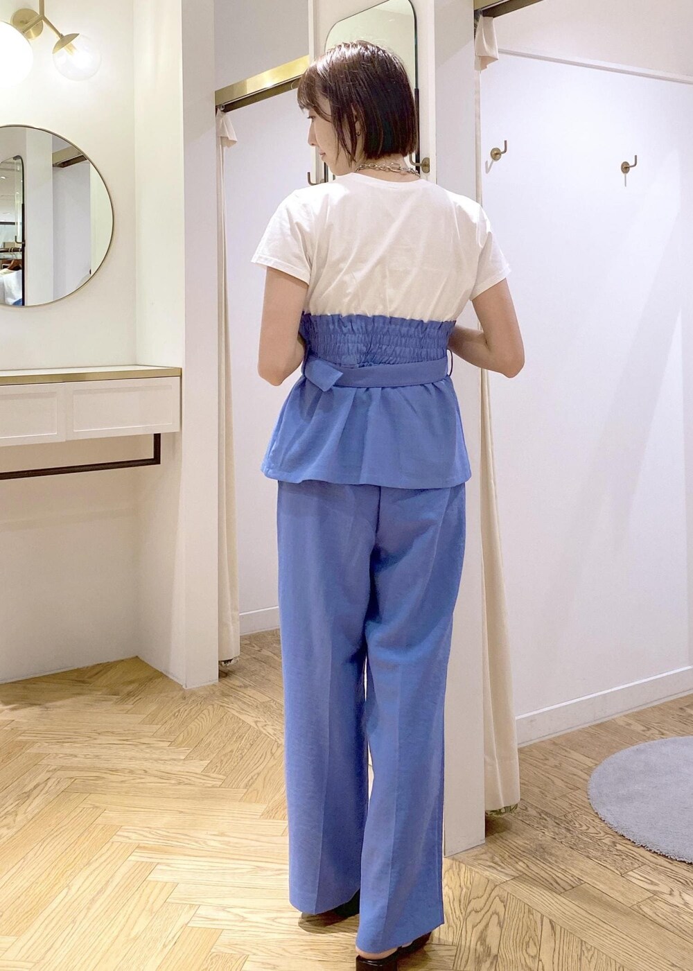 ブルー系のスラックス、ブラック系のショルダーバッグ、ブラック系のサンダルを着用したレディースの春コーディネートの2枚目の写真