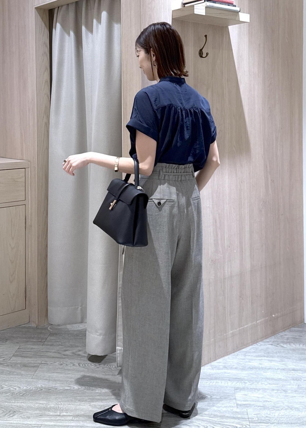ブラック系のハンドバッグ、グレー系のその他パンツ、ブラック系のパンプスを着用したレディースの春コーディネートの3枚目の写真