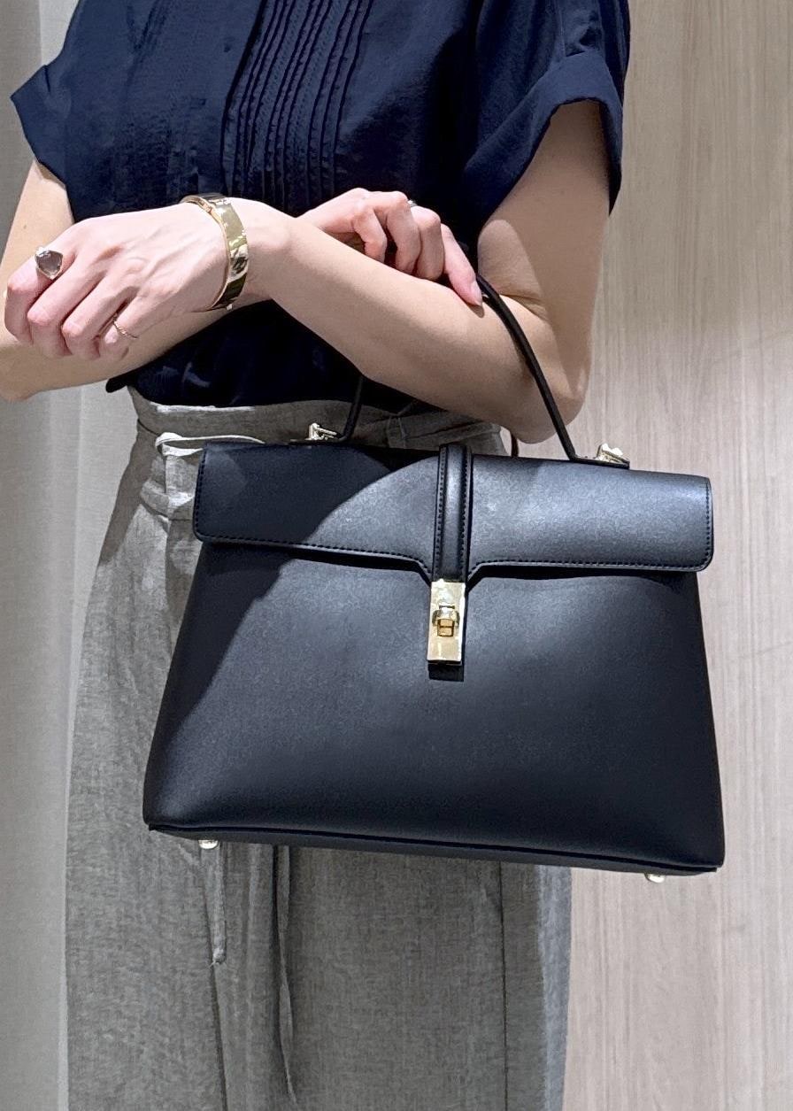 ブラック系のハンドバッグ、グレー系のその他パンツ、ブラック系のパンプスを着用したレディースの春コーディネートの10枚目の写真