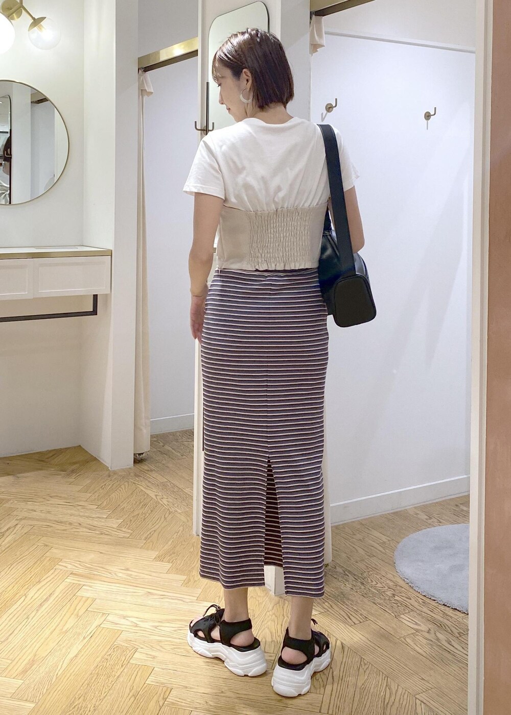 ブラック系のショルダーバッグ、ブラック系のサンダル、ブラック系のキャミソールを着用したレディースの夏コーディネートの2枚目の写真