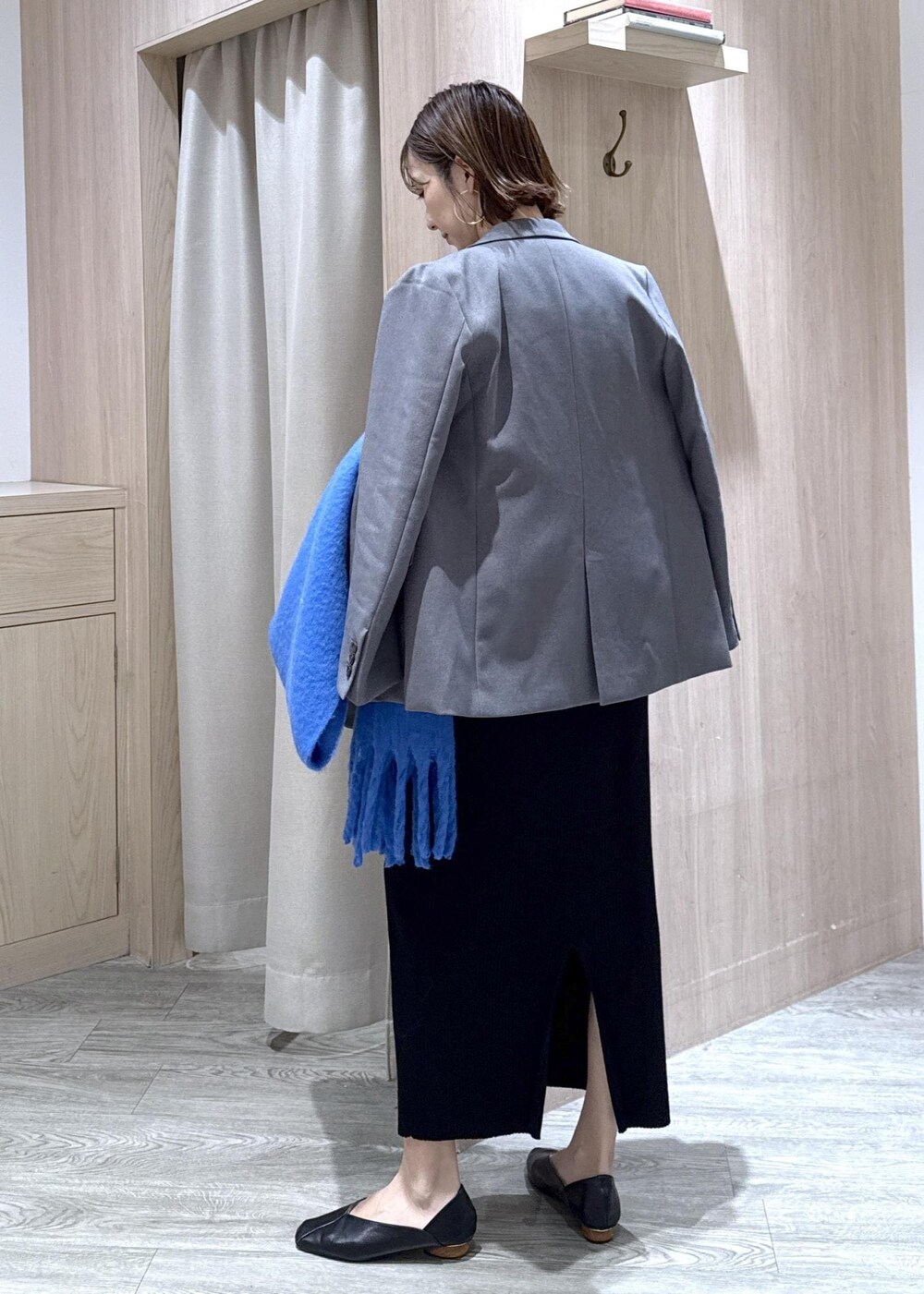 グレー系のテーラードジャケット、ブラック系のショルダーバッグ、ブラック系のワンピースを着用したレディースの秋コーディネートの2枚目の写真