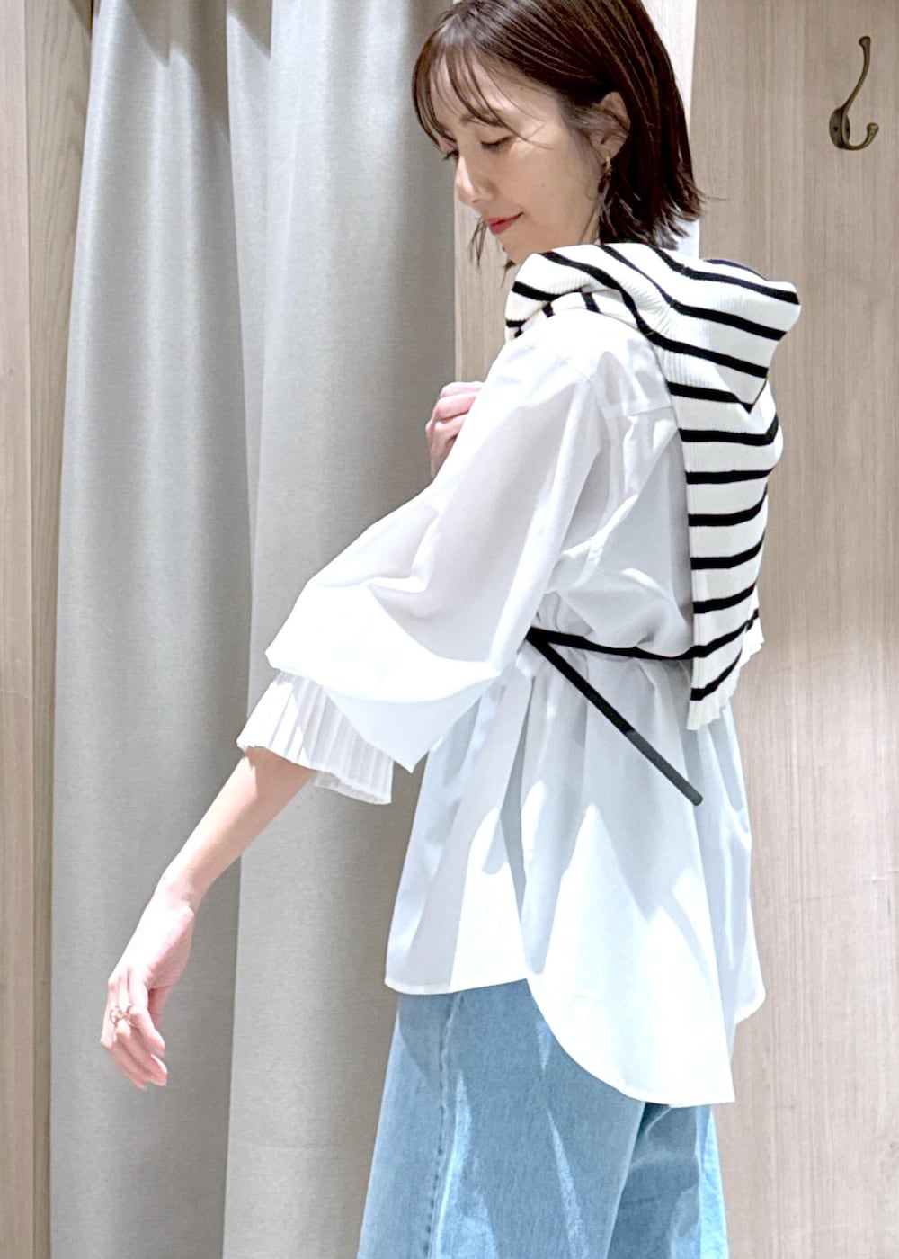 ブラック系のハンドバッグ、ブラック系のローファー、ホワイト系のシャツ/ブラウスを着用したレディースの春コーディネートの8枚目の写真