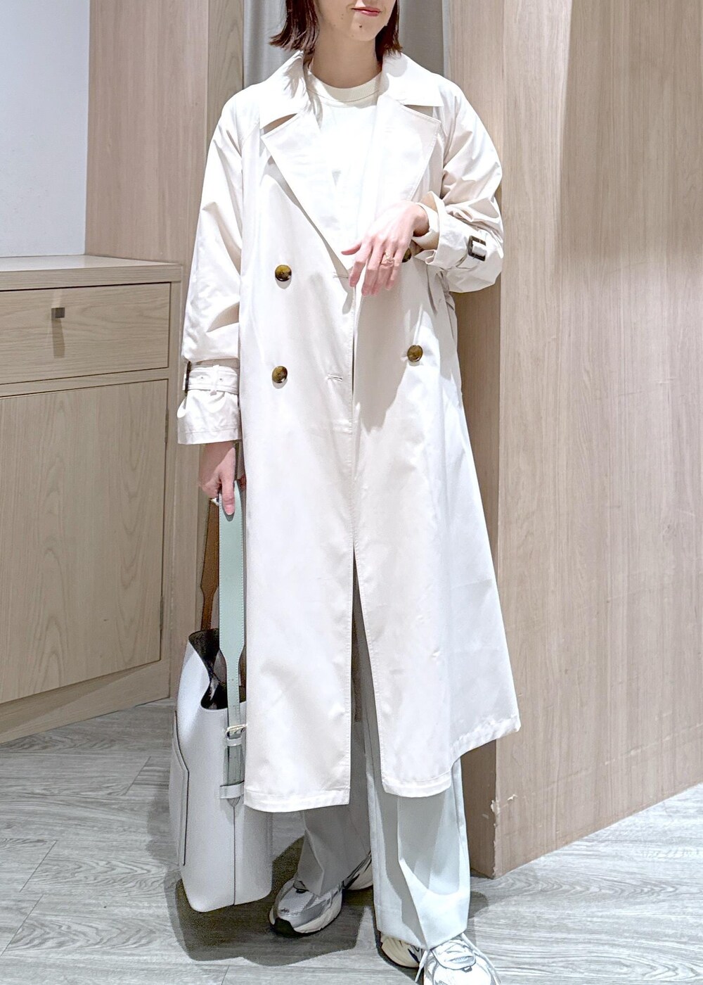 ホワイト系のニット/セーター、ホワイト系のトレンチコート、グリーン系のスラックスを着用したレディースの冬コーディネートの5枚目の写真