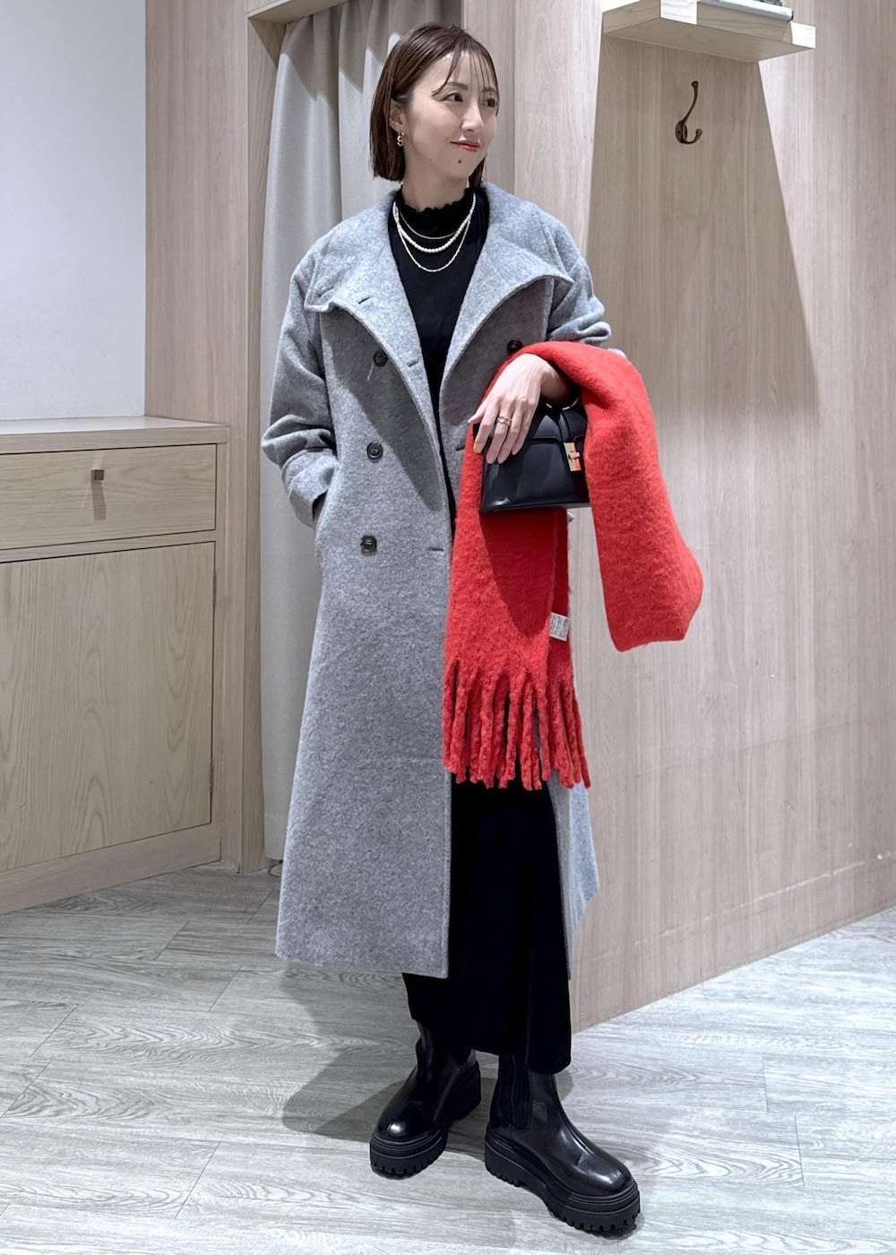 ブラック系のショルダーバッグ、ブラック系のブーツ、ブラック系のワンピースを着用したレディースの冬コーディネートの4枚目の写真