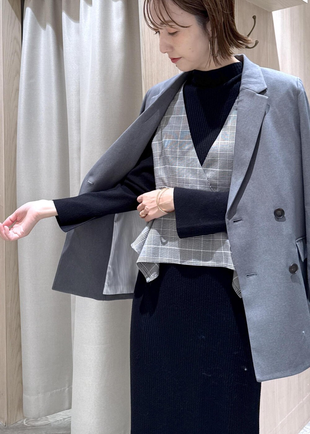 グレー系のテーラードジャケット、ブラック系のショルダーバッグ、ブラック系のワンピースを着用したレディースの冬コーディネートの8枚目の写真