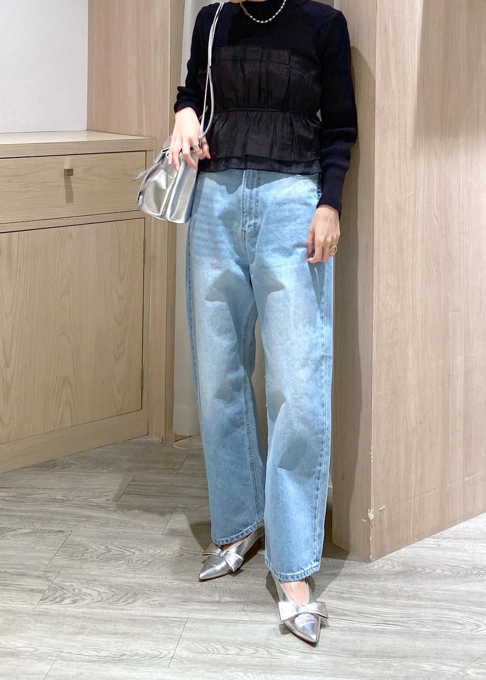 シルバー系のパンプス、ブラック系のニット/セーター、シルバー系のショルダーバッグを着用したレディースの冬コーディネートの5枚目の写真