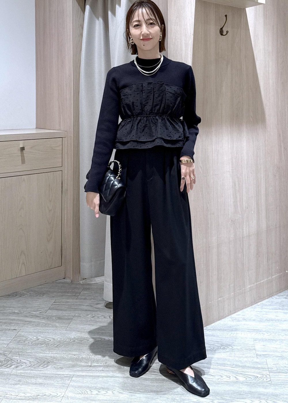 ブラック系のその他パンツ、ブラック系のニット/セーター、ブラック系のショルダーバッグを着用したレディースの冬コーディネートの10枚目の写真