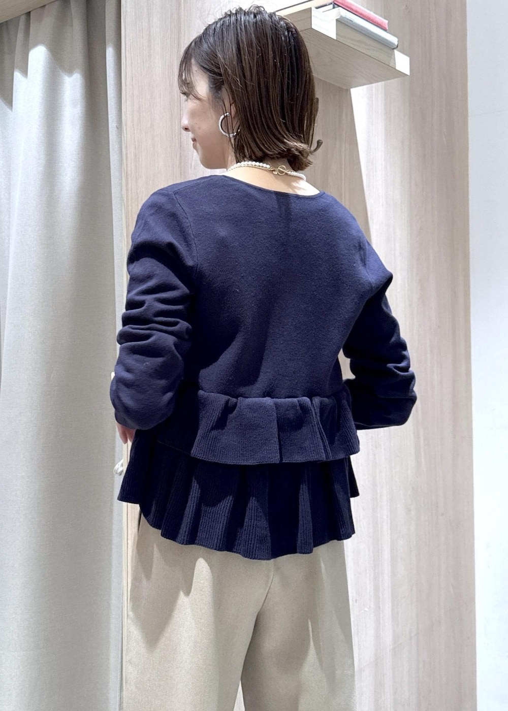 ベージュ系のスラックス、その他のハンドバッグ、ブルー系のカーディガン/ボレロを着用したレディースの冬コーディネートの10枚目の写真