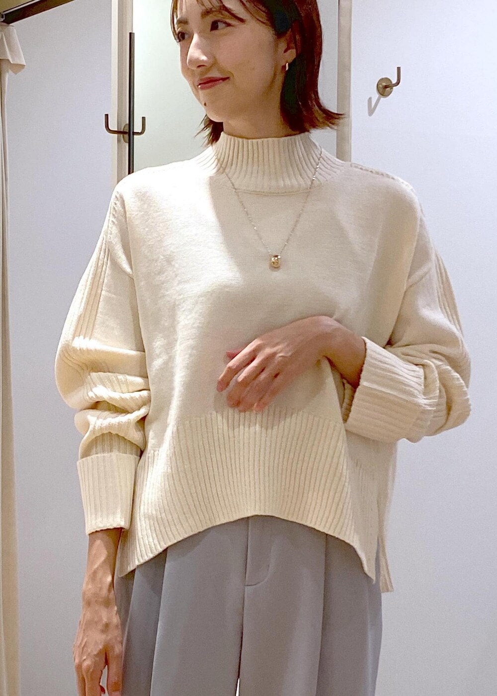 シルバー系のパンプス、ブラック系のショルダーバッグ、ブルー系のスラックスを着用したレディースの秋コーディネートの6枚目の写真