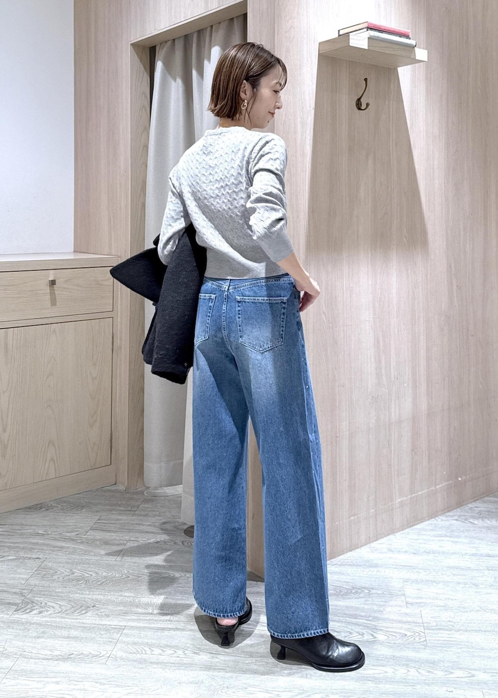 グレー系のカーディガン/ボレロ、ブラック系のブルゾン、ブルー系のデニムパンツを着用したレディースの秋コーディネートの8枚目の写真