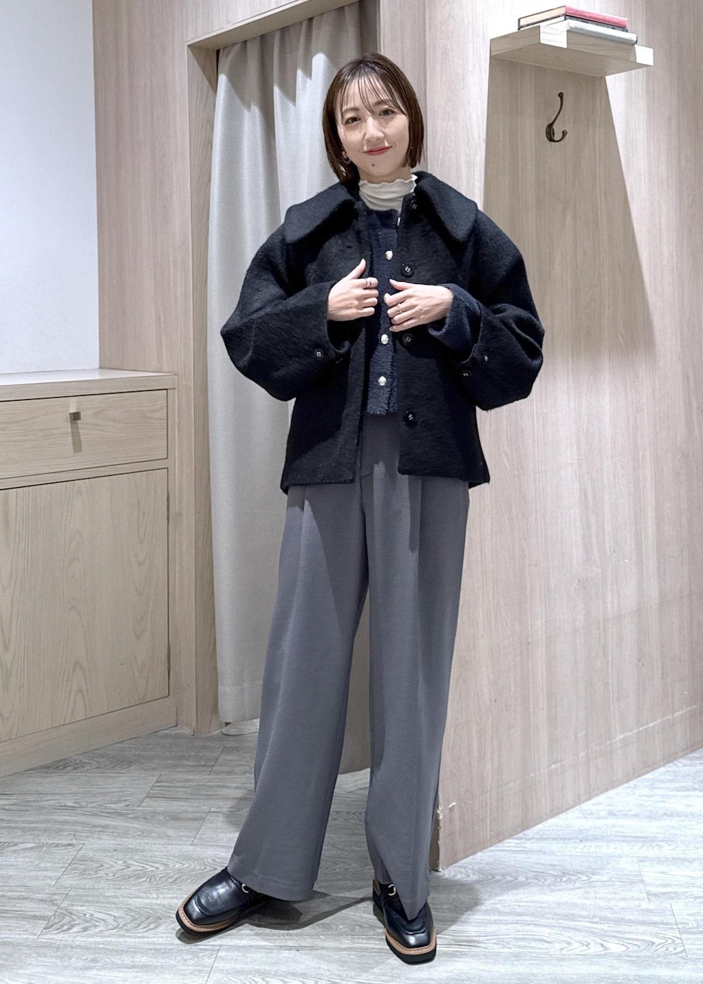 ホワイト系のショルダーバッグ、ブラック系のローファー、ブルー系のカーディガン/ボレロを着用したレディースの冬コーディネートの2枚目の写真