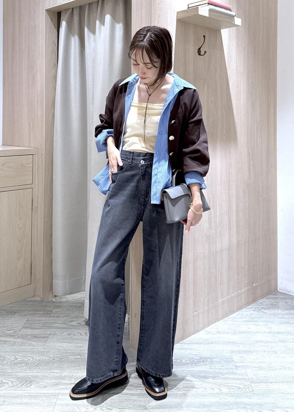 グレー系のショルダーバッグ、ブラック系のローファー、ホワイト系のキャミソールを着用したレディースの秋コーディネートの2枚目の写真