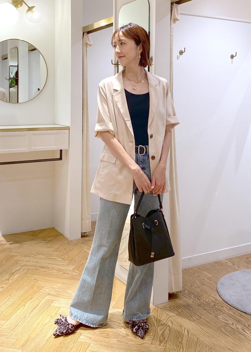 ブラック系のキャミソール、ホワイト系のテーラードジャケット、その他のサンダルを着用したレディースの夏コーディネートの7枚目の写真