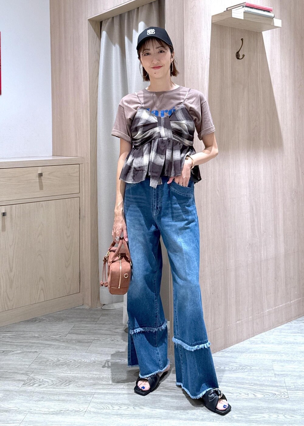 ブラック系のサンダル、ブルー系のデニムパンツ、ブラック系のキャミソールを着用したレディースの夏コーディネートの2枚目の写真