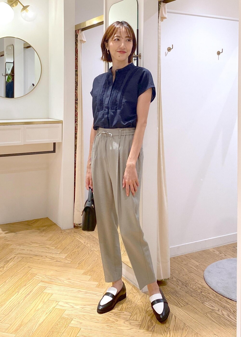 ブラック系のキャミソール、ブラック系のローファー、ブラック系のショルダーバッグを着用したレディースの夏コーディネートの2枚目の写真