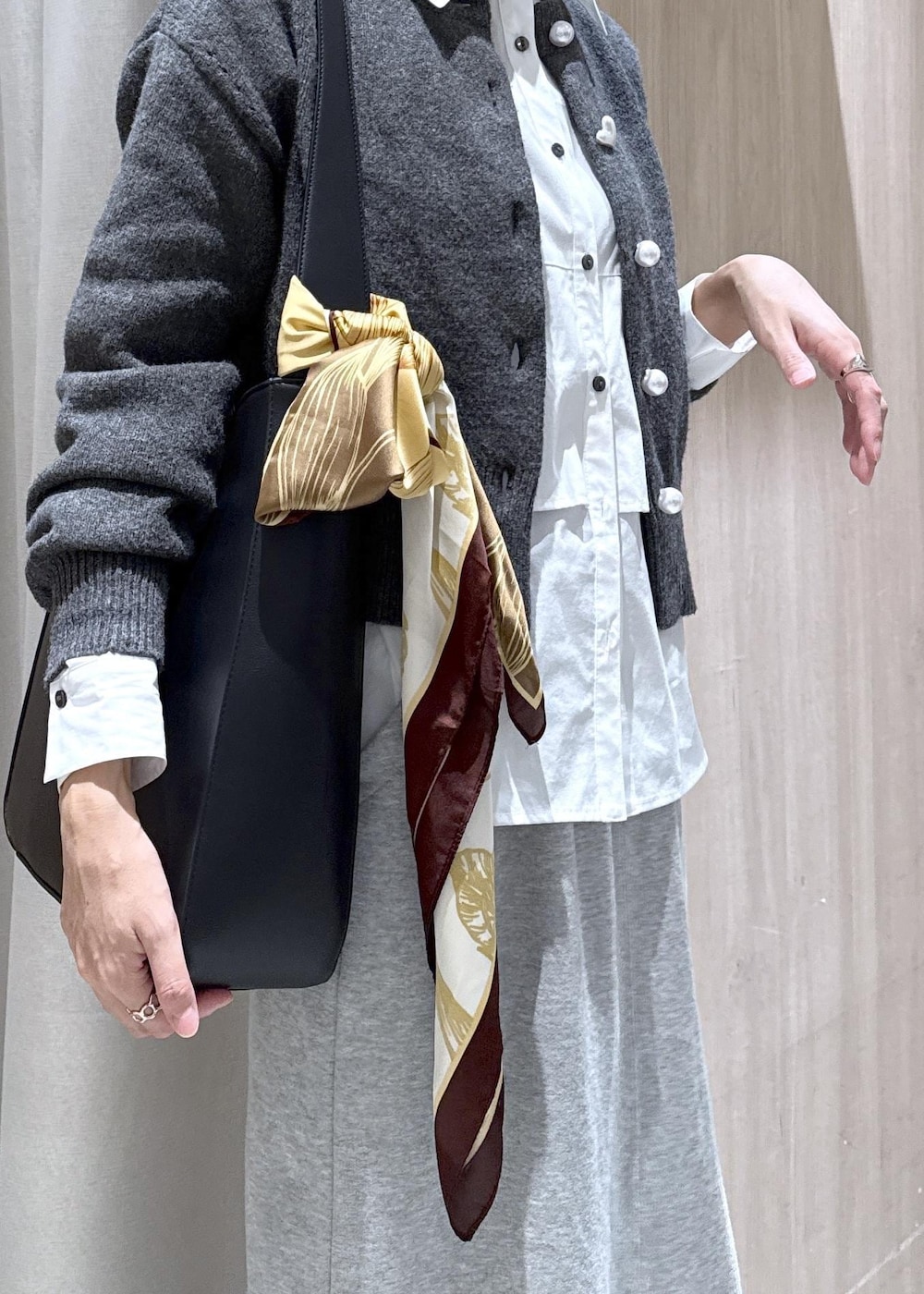 ブラック系のトートバッグ、グレー系のスカート、ホワイト系のシャツ/ブラウスを着用したレディースの秋コーディネートの10枚目の写真