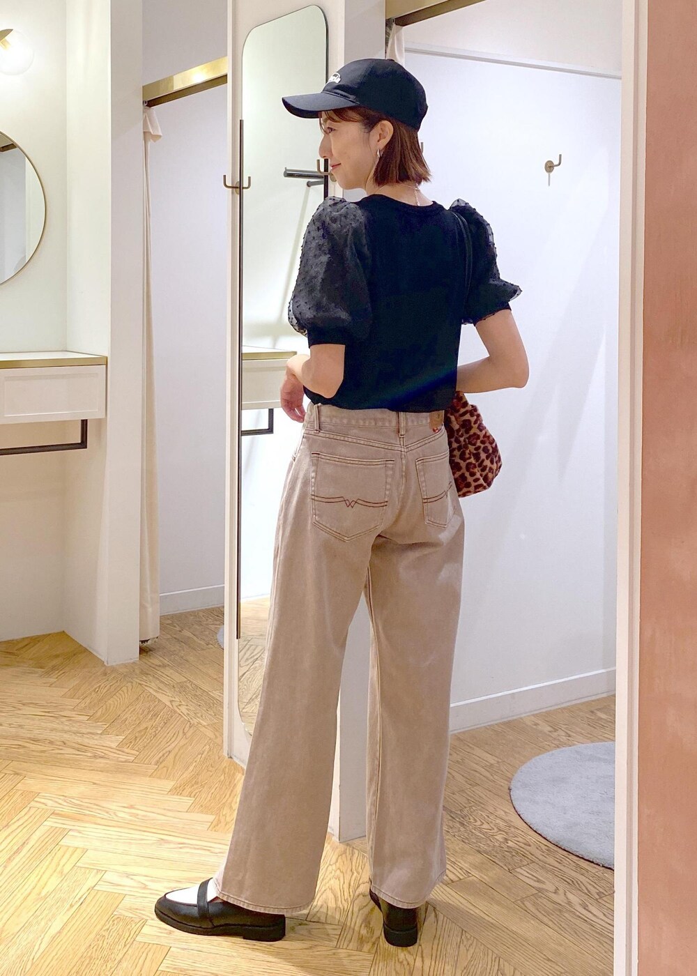 ブラック系のローファー、ブラック系のニット/セーター、ブラウン系のデニムパンツを着用したレディースの夏コーディネートの2枚目の写真