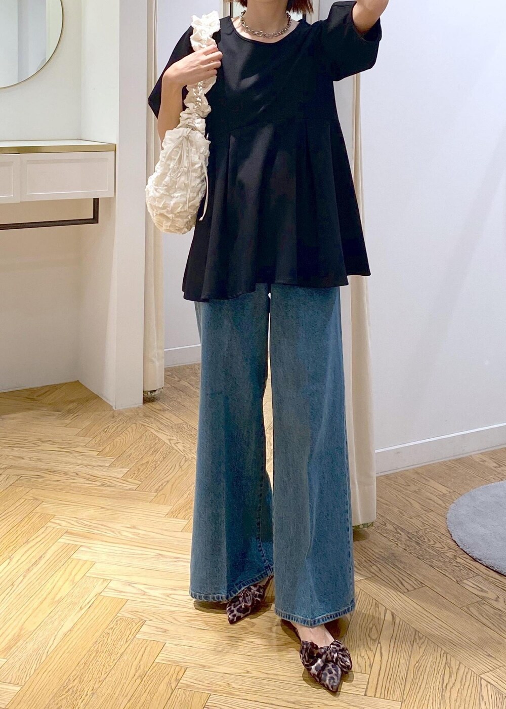 その他のサンダル、ブラック系のTシャツ/カットソー、ブルー系のデニムパンツを着用したレディースの秋コーディネートの5枚目の写真