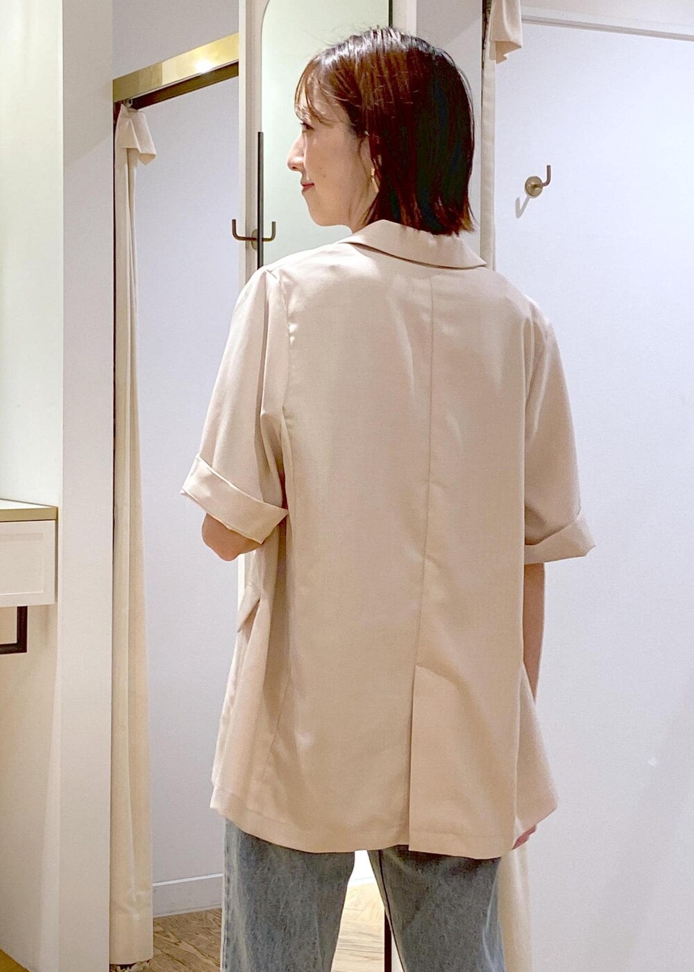 ブラック系のキャミソール、ホワイト系のテーラードジャケット、その他のサンダルを着用したレディースの夏コーディネートの6枚目の写真