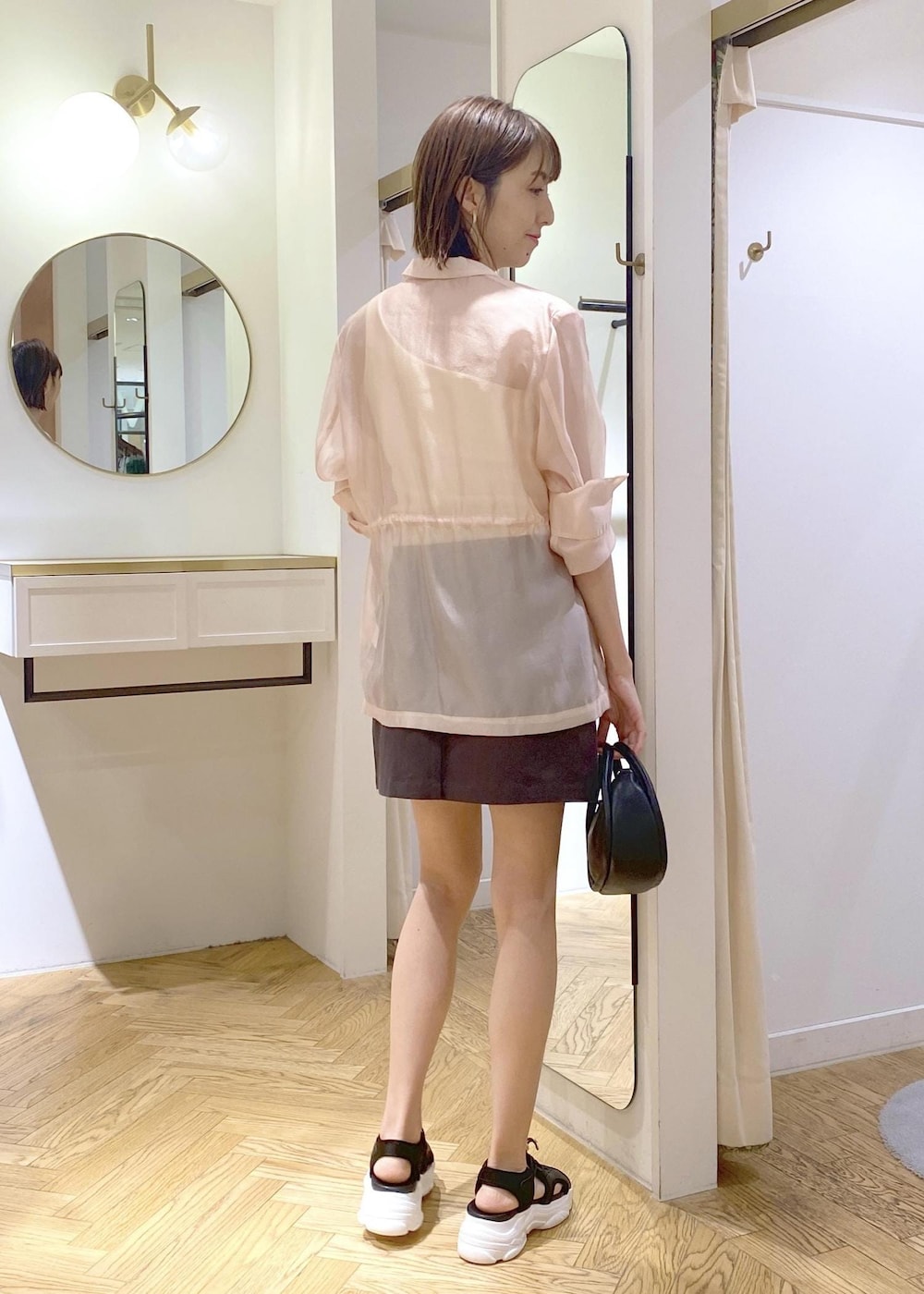 ホワイト系のタンクトップ、ブラック系のショルダーバッグ、ブラック系のサンダルを着用したレディースの春コーディネートの2枚目の写真